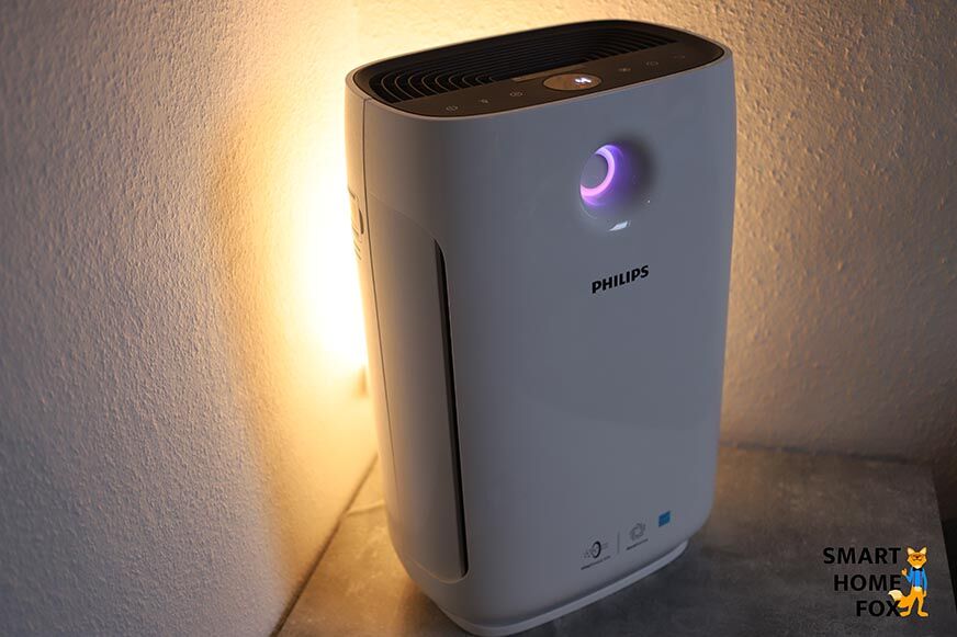 Der Philips AC2889/10 Luftreiniger steht auf einem Tisch, der Farbring leuchtet magenta